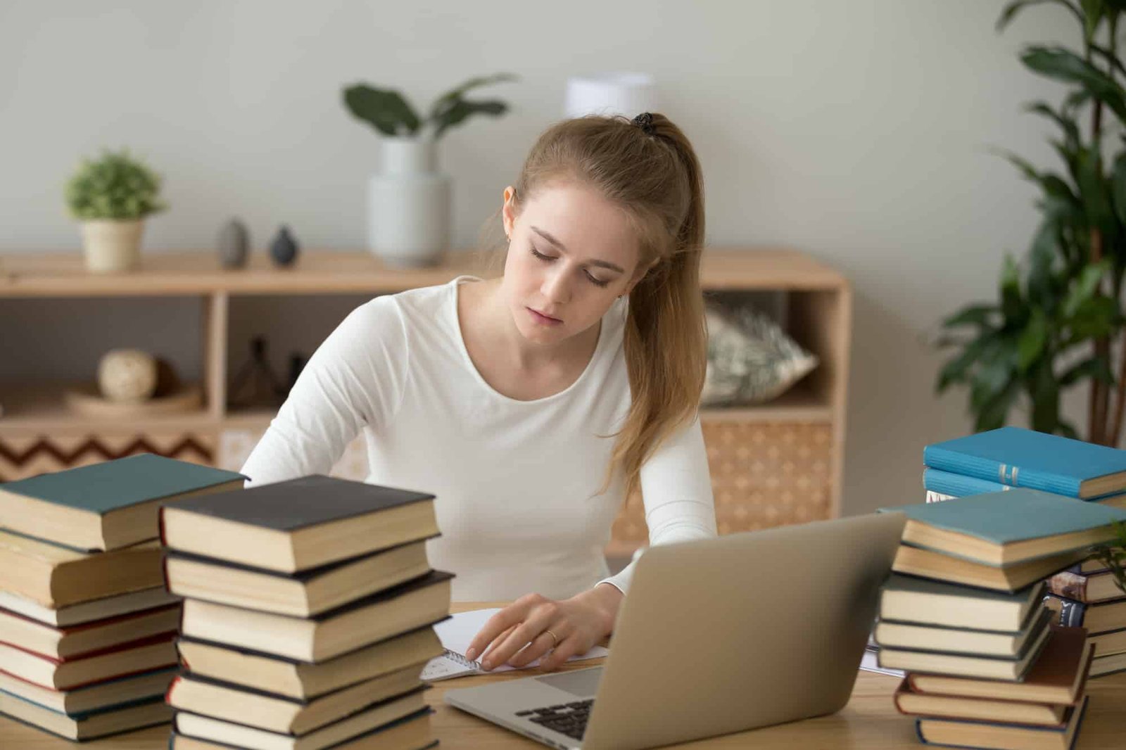 Teen Girl Preparing For Exam Writing Essay Coursework In Notebook